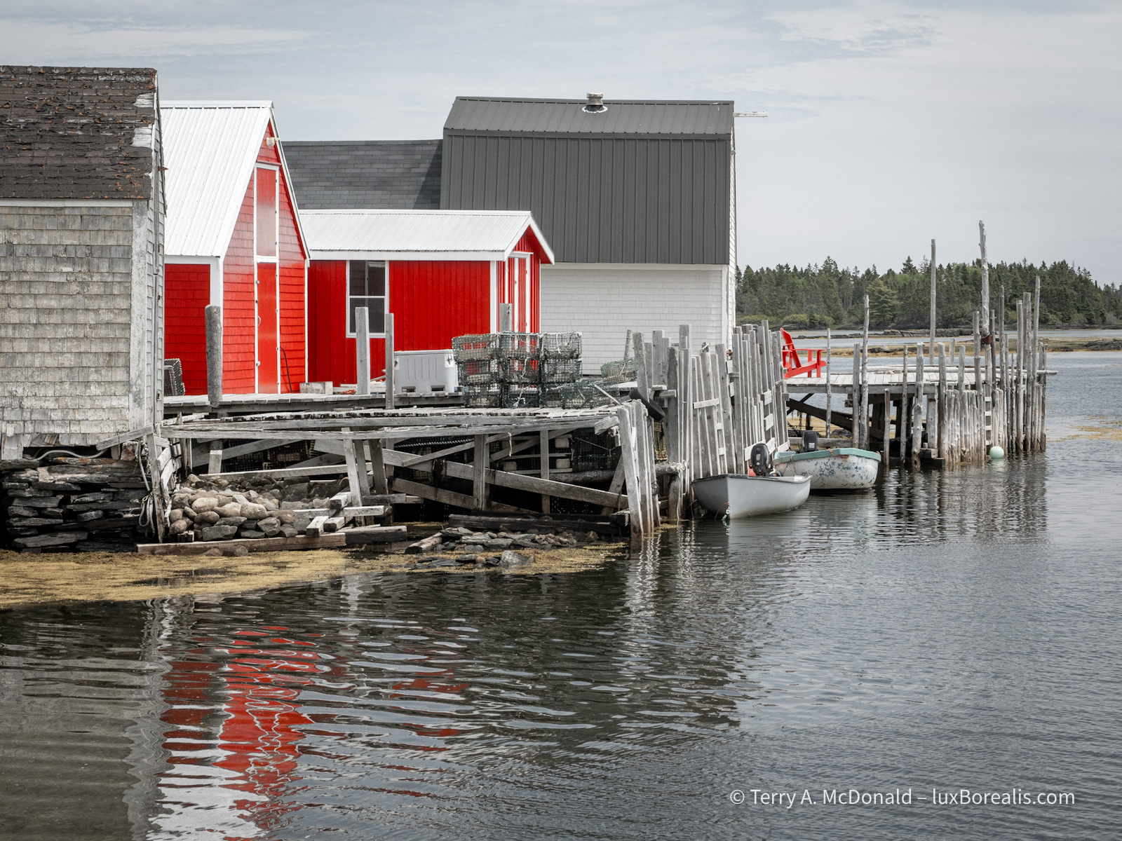 Old and New
A couple of fishing huts with new bright red siding stand out from the others in this muted-colour photograph