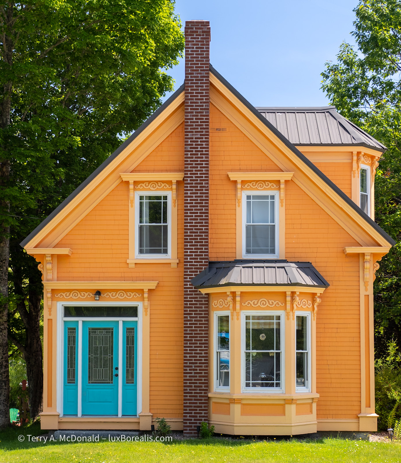 Down East Sunshine, Mahone Bay
The facade of a bright sunshine-yellow house with lighter yellow trim is set off by a bright turquoise door.