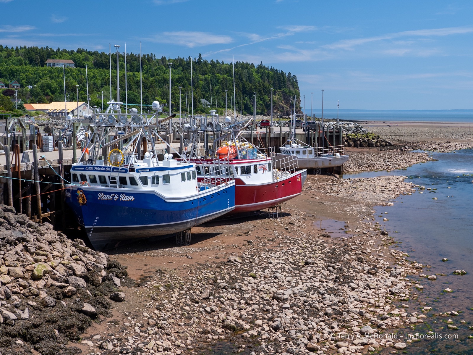 Alma Harbour, Low Tide
Brightly coloured fishing boats are high and dry with the sea floor exposed at low tide.